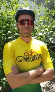 Ludovic en tenue CommeUnVelo qui croise les bras avec un casque et des lunettes